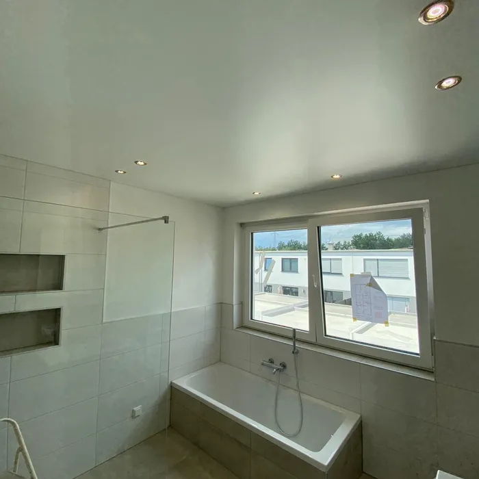 Badezimmer mit Spanndecke, Badewanne und Glasdusche