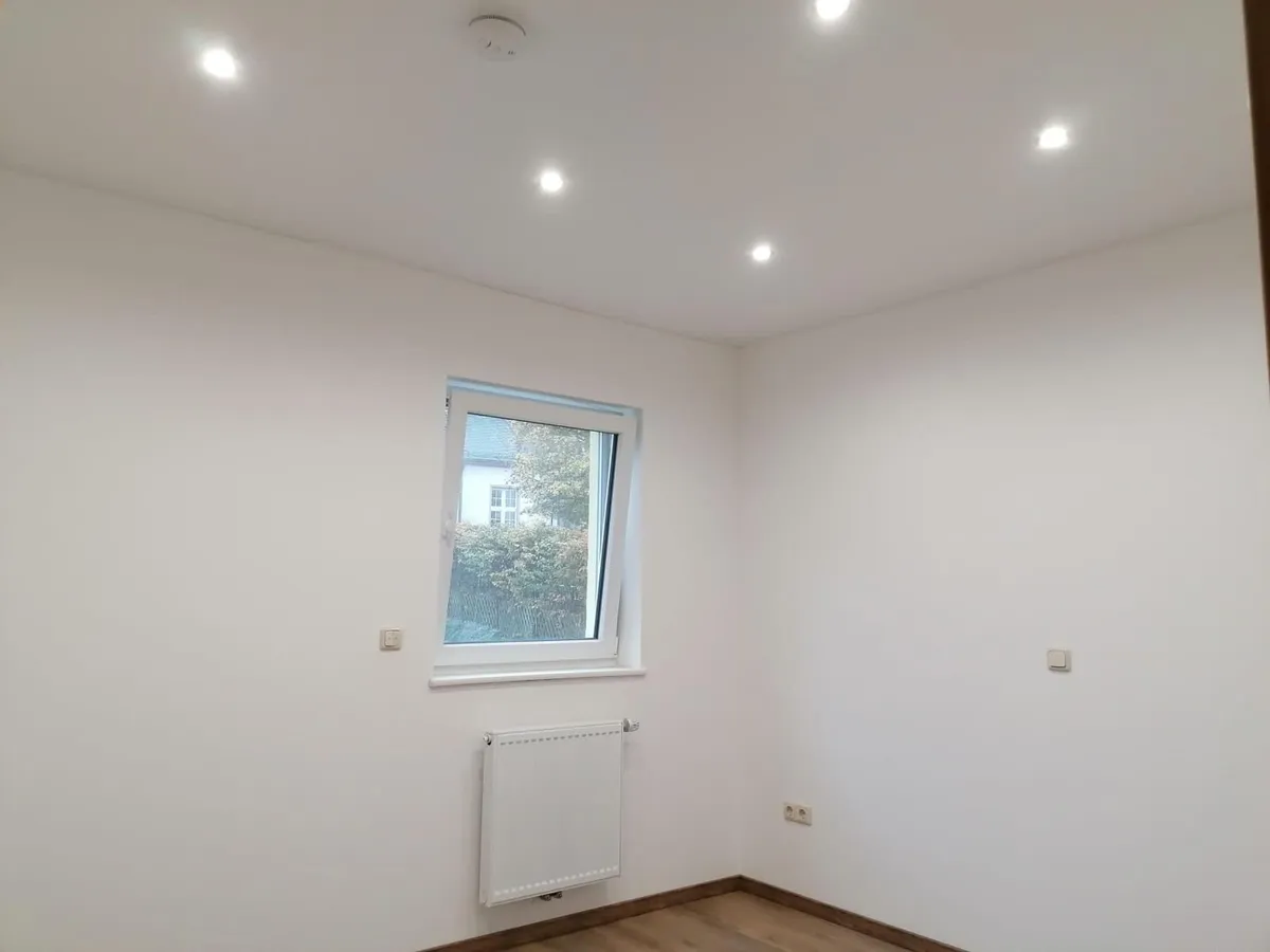 Fertiggestellter Raum mit Spanndecke, Fenster und Bodenbelag